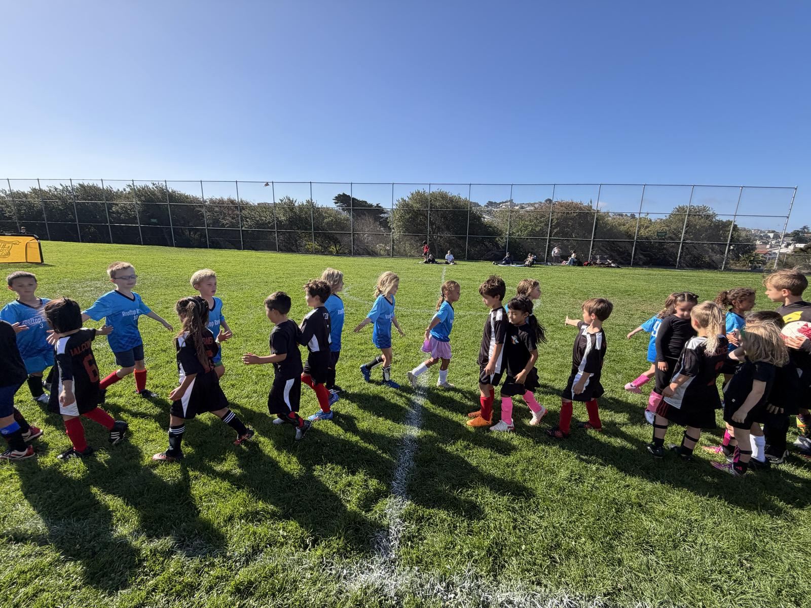 Children greeting each other after a parent-organized soccer game