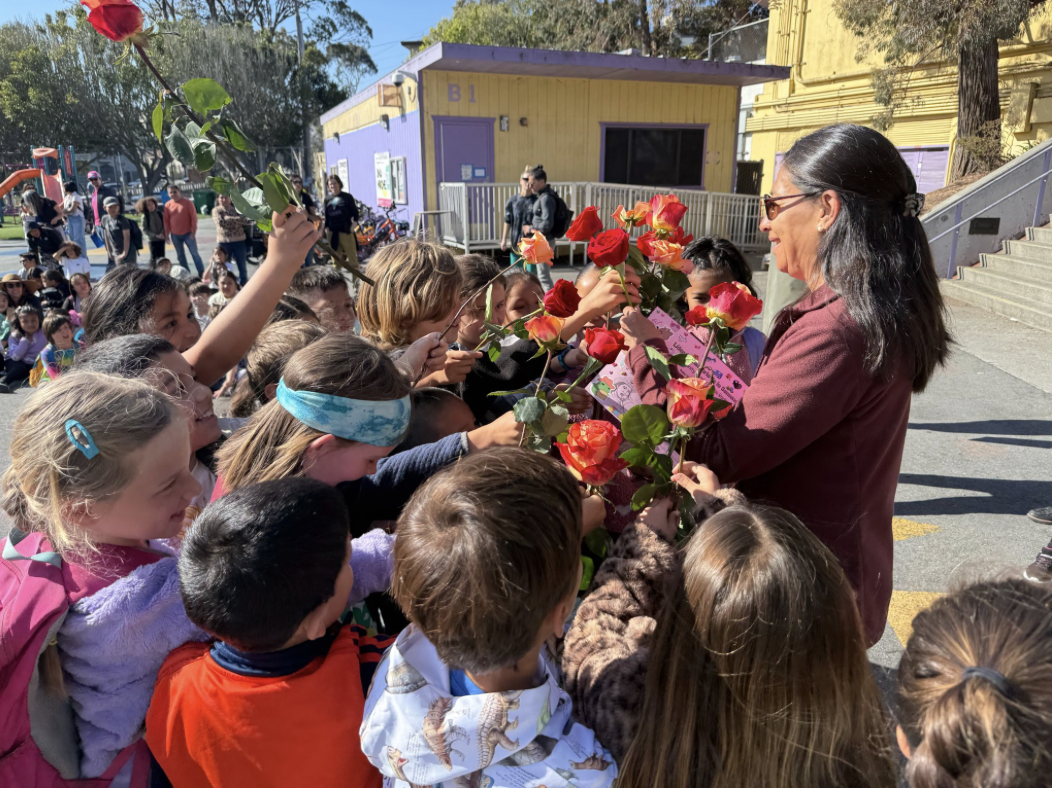 Students giving flowers to a teacher during Teacher Appreciation Week